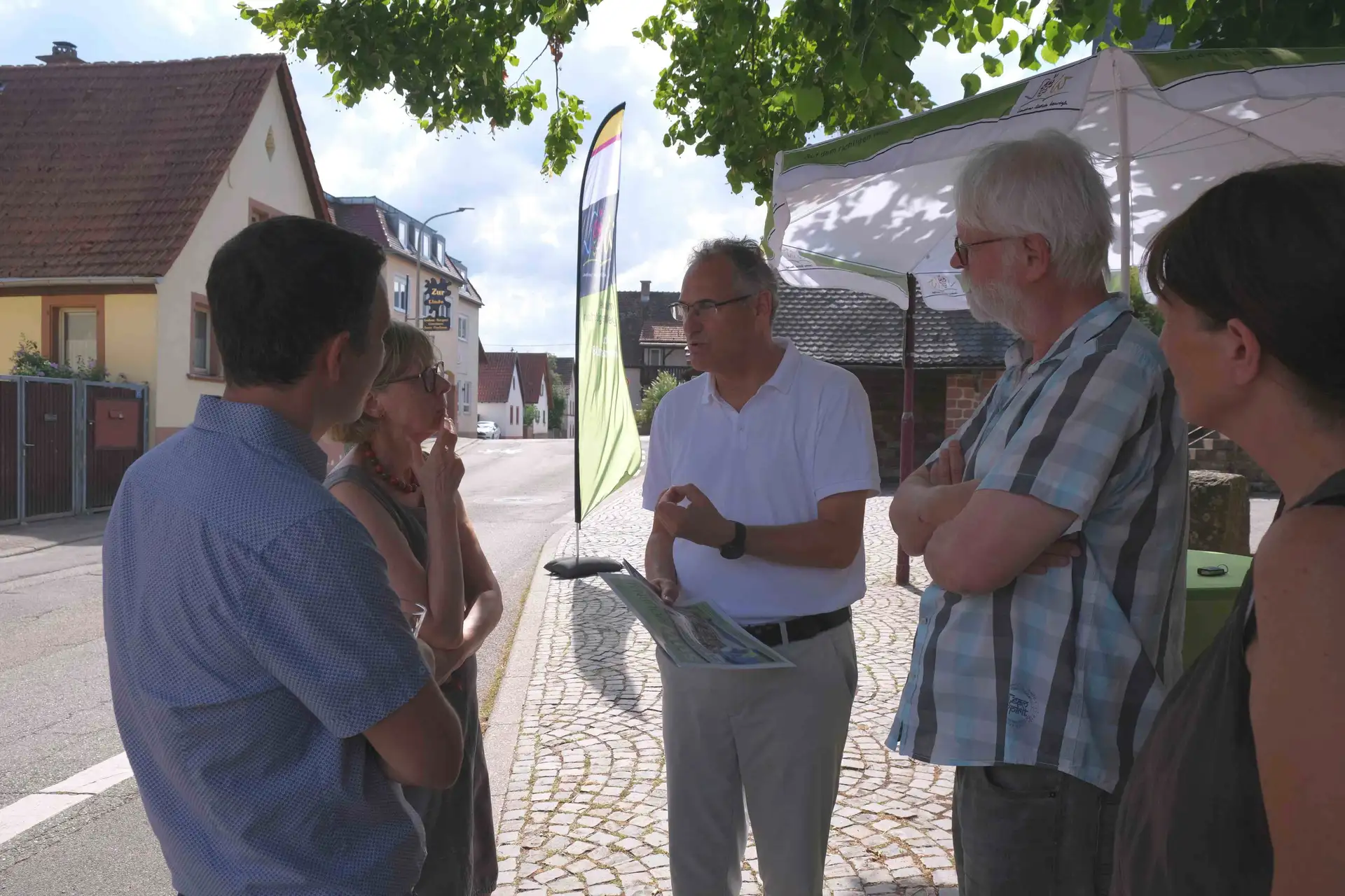 Landrat Dietmar Seefeldt (Mitte) und Bürgermeister Christian Burkhart (links) im Gespräch mit Silzer Bürgerinnen und Bürgern auf dem Lindenplatz.