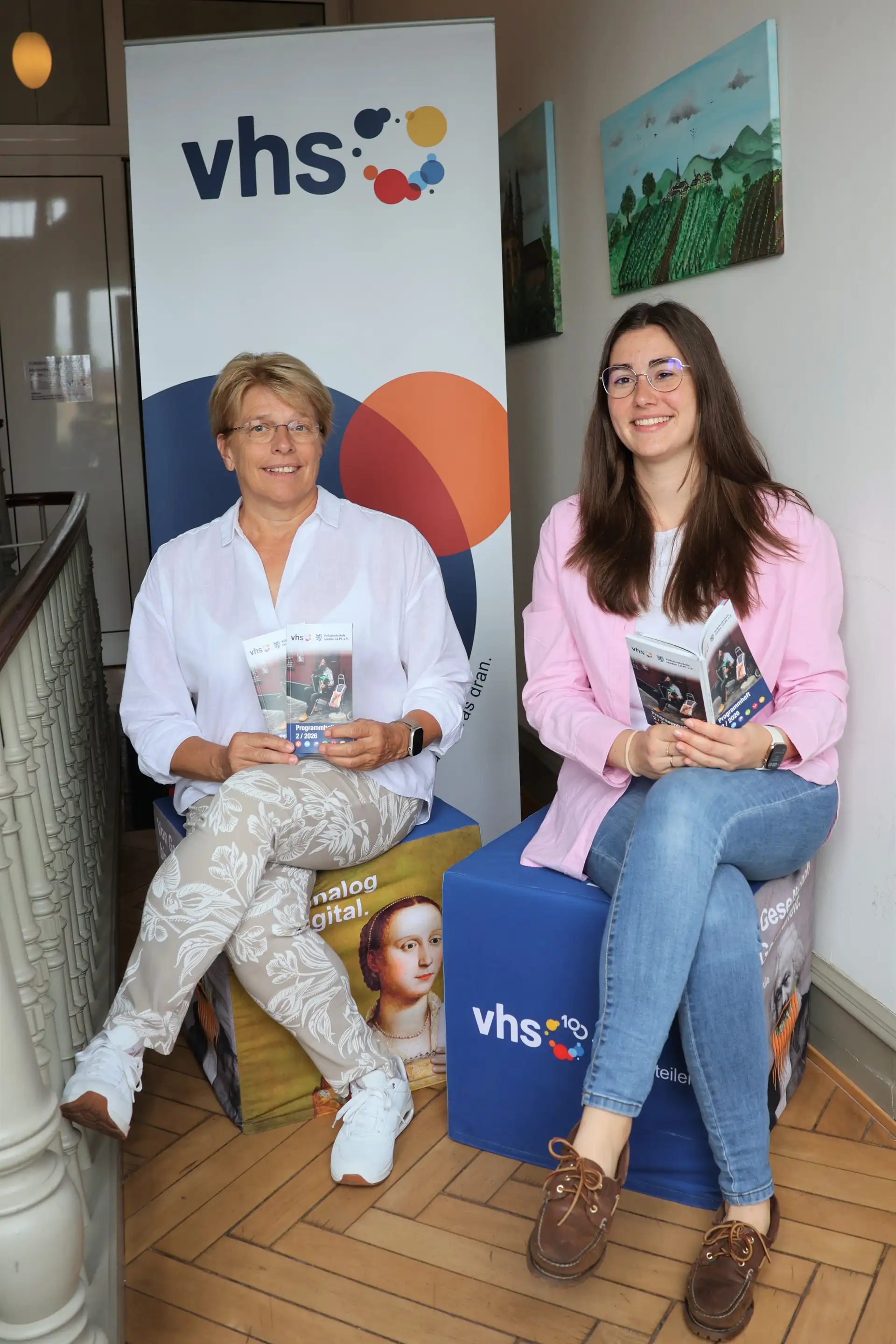 Die Leiterin der VHS Landau, Sigrid Gensheimer (links), und die Vorsitzende der VHS Landau und Beigeordnete Lena Dürphold (rechts) präsentieren das neue Herbstprogramm 2026 der VHS Landau. (Quelle: Stadt Landau)