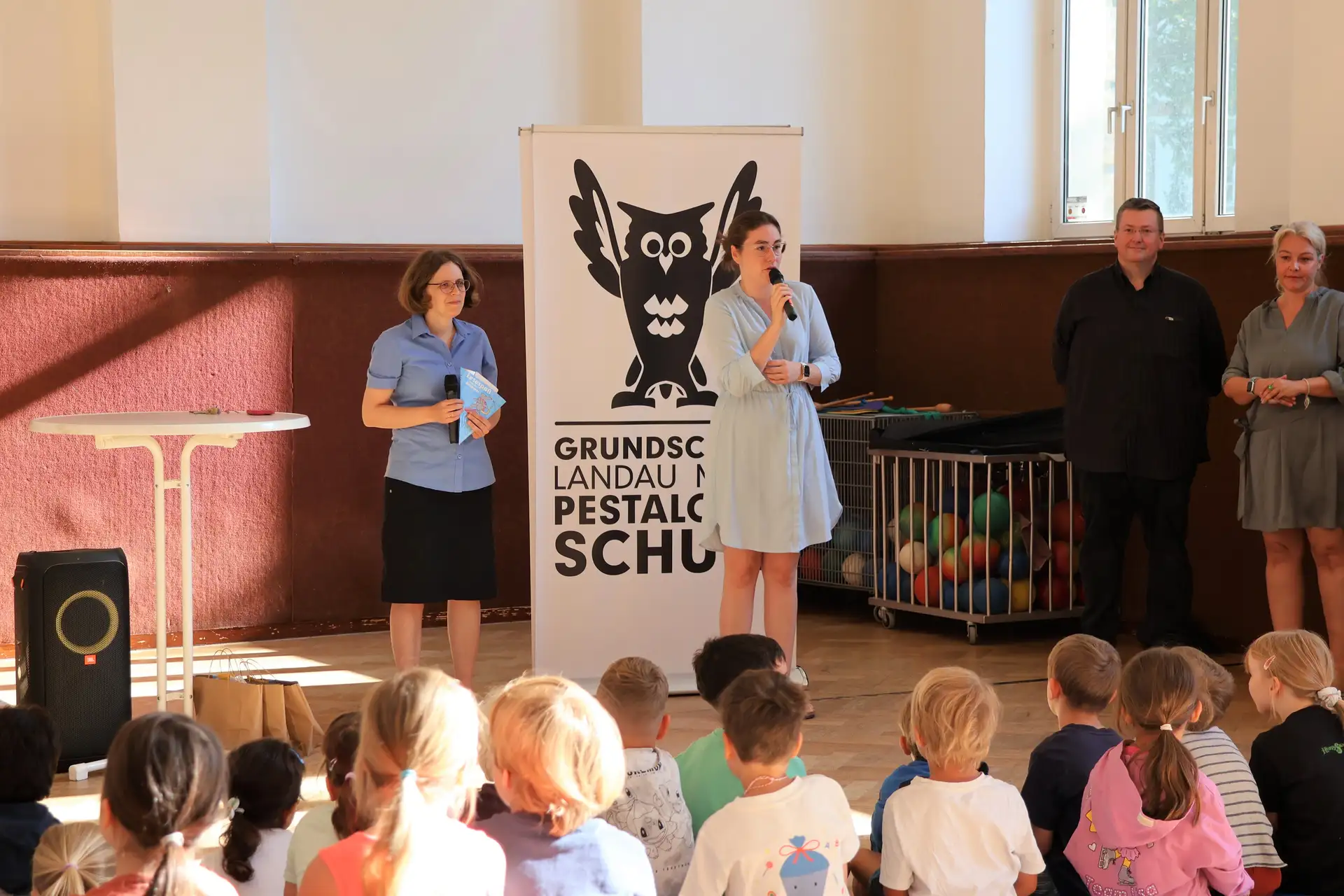 Erstklässlerinnen und Erstklässler der Pestalozzischule erhalten Schultüten von Bibliotheksleiterin Amelie Löhlein (links) und Schuldezernentin Lena Dürphold (2. v. l.).