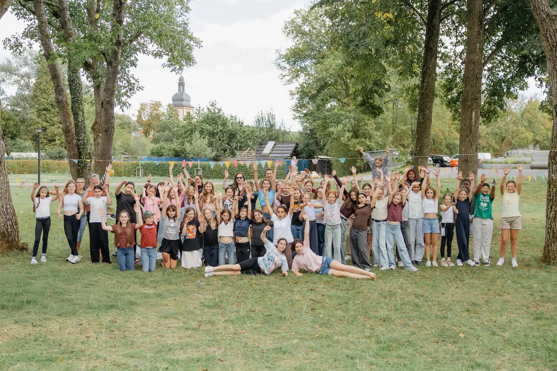 Mehrere Mädchen beim Picknick im Stadtpark: sitzend, lachend und gemeinsam im Freien.