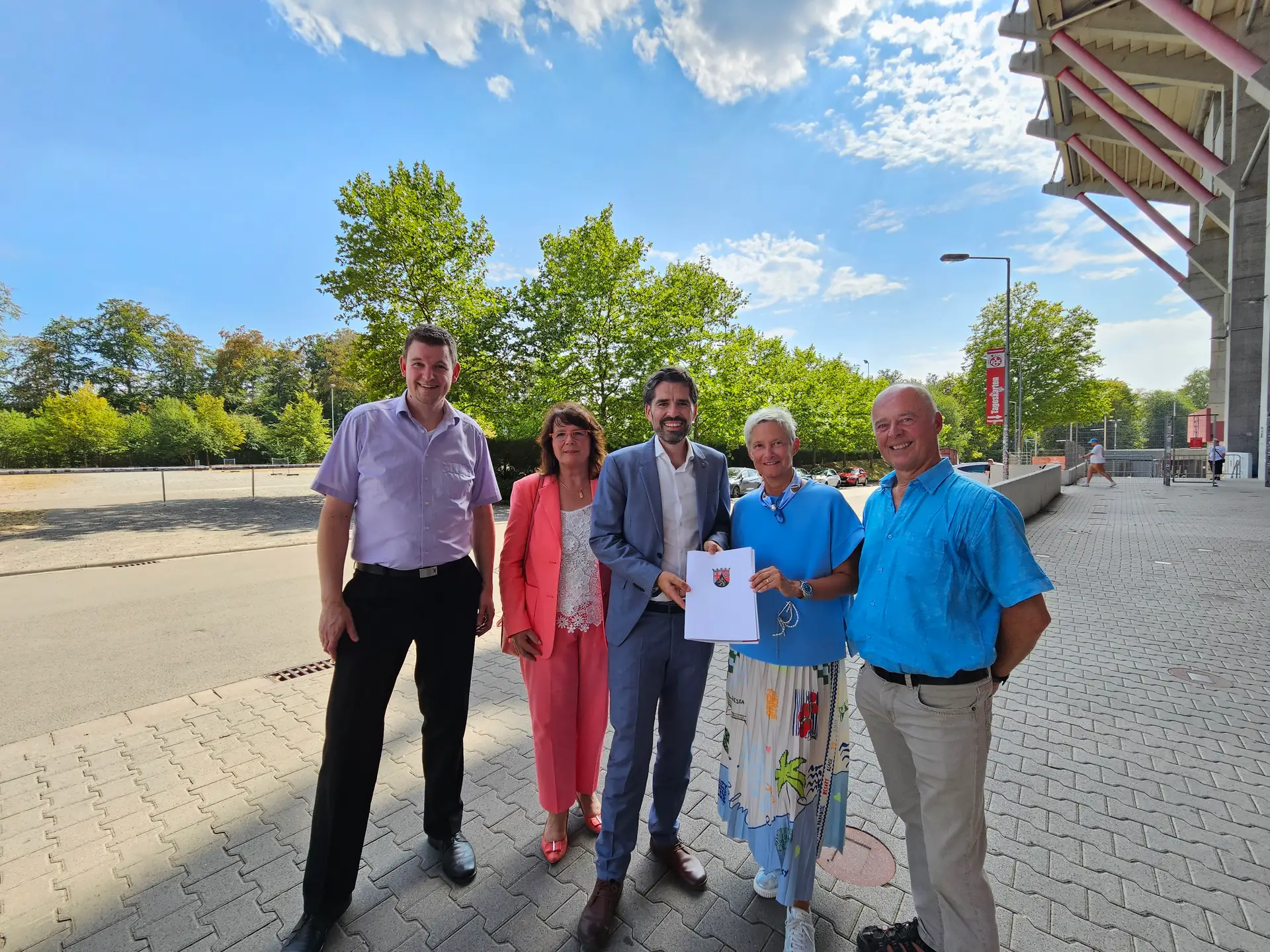 Minister Sven Teuber und Oberbürgermeisterin Beate Kimmel trafen sich zur Förderbescheidübergabe vor Ort auf dem Betzenberg. Links Andreas Kühn, Referent im Ministerium für Kommunen, Bauen, Wohnen und Kultur, und Elke Franzreb, Leiterin Referat Stadtentwicklung, rechts Joachim Wilhelm, ebenfalls Referat Stadtentwicklung.