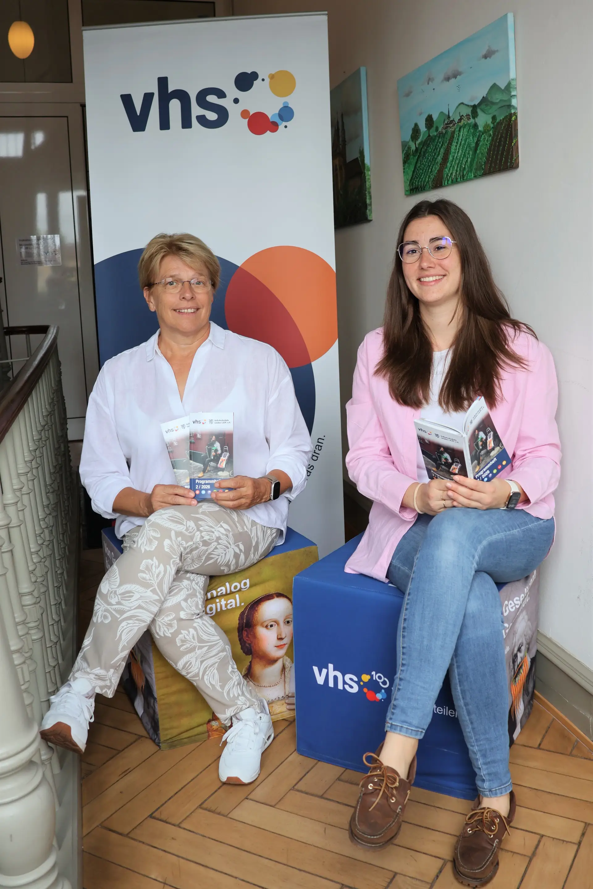 Die Leiterin der VHS Landau, Sigrid Gensheimer (links), und die Vorsitzende der VHS Landau und Beigeordnete Lena Dürphold (rechts) präsentieren das neue Herbstprogramm 2026 der VHS Landau. (Quelle: Stadt Landau)
