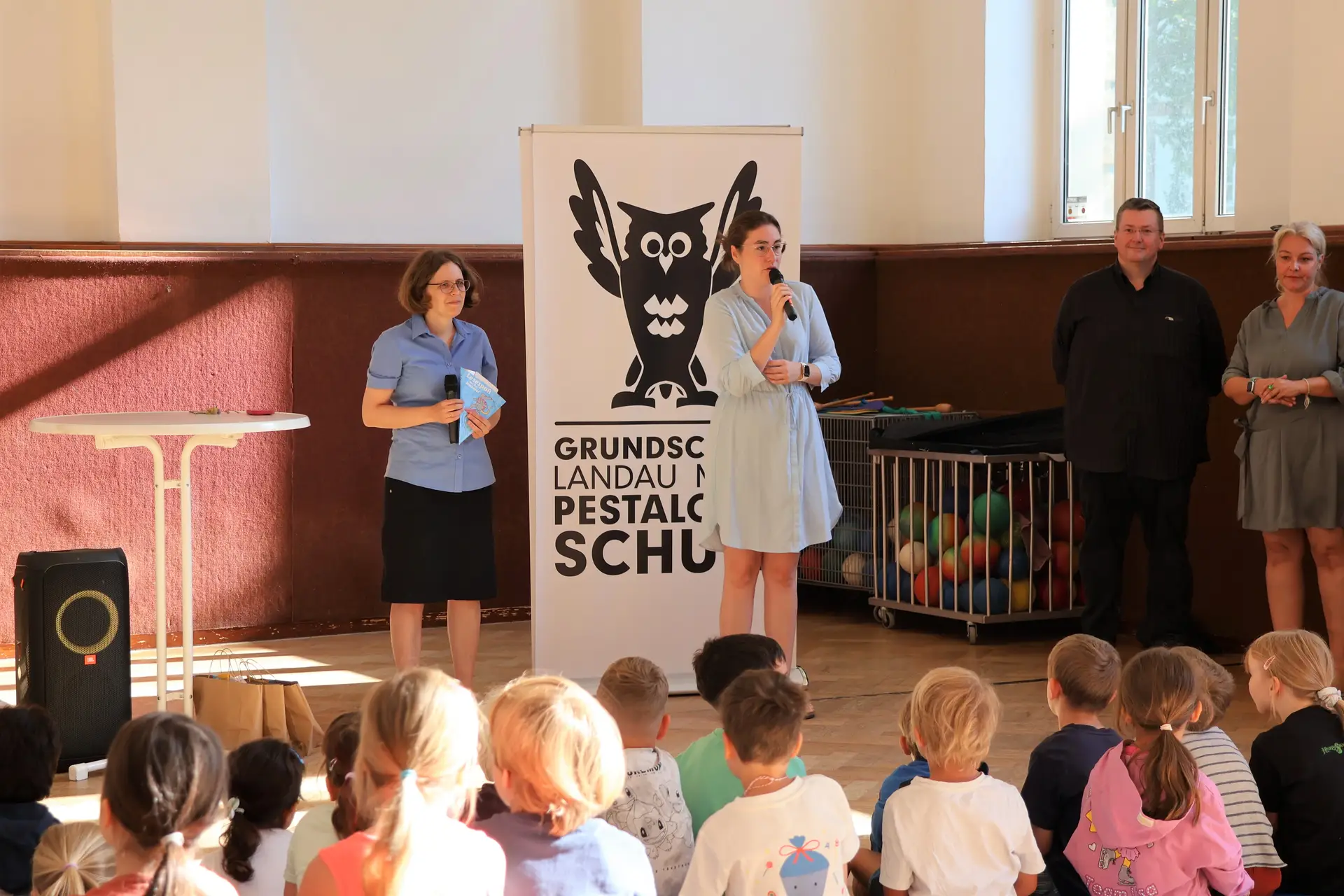 Erstklässlerinnen und Erstklässler der Pestalozzischule erhalten Schultüten von Bibliotheksleiterin Amelie Löhlein (links) und Schuldezernentin Lena Dürphold (2. v. l.).