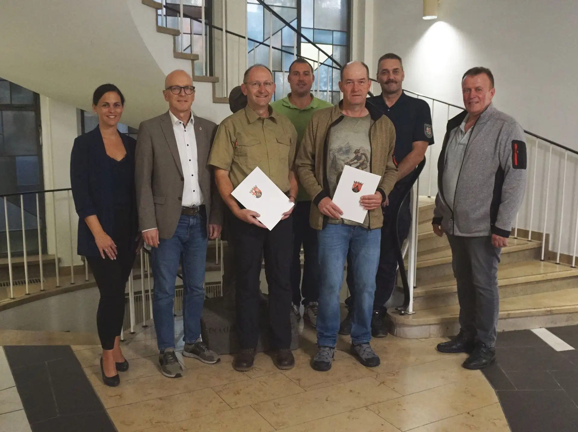 Sieben Personen stehen für ein Gruppenfoto zum 40-jährigen Dienstjubiläum von Dirk Lanz und Thomas Knechtges.